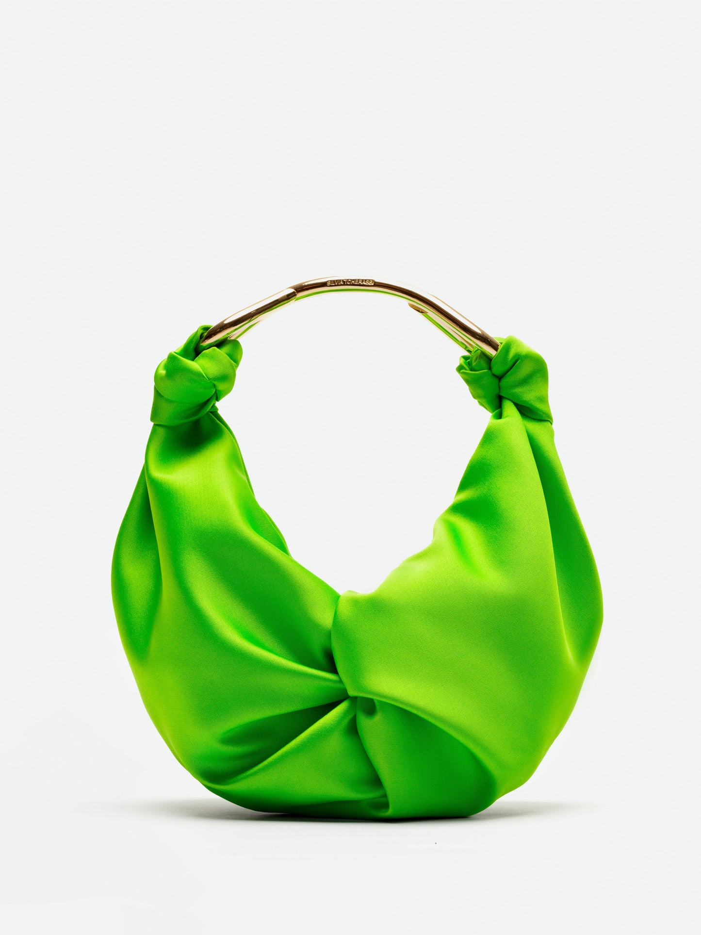 El Bolso Sofia Small es un bolso de tela suave de color verde brillante que presenta un diseño retorcido. Incluye un asa circular dorada con un patrón texturizado que resalta la exquisita artesanía textil italiana sobre un fondo blanco liso.