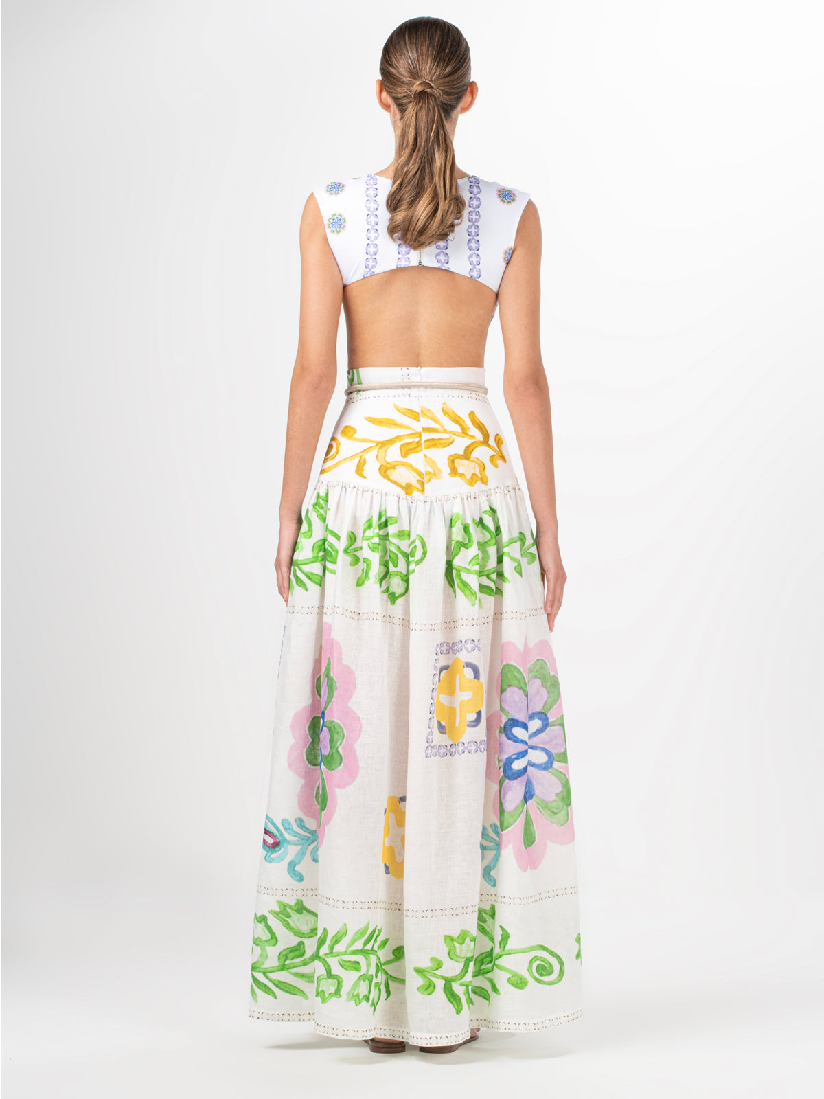 A woman wearing an Abla Skirt Multicolor Floral Print with abstract floral designs.
