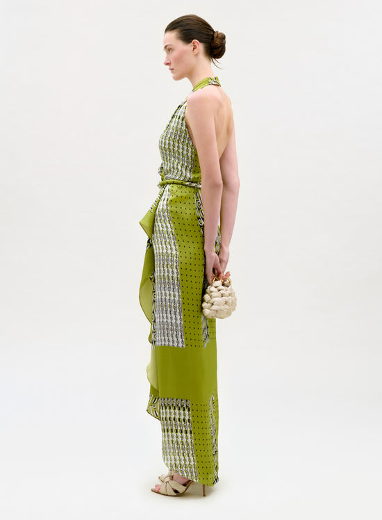 Woman wearing a green and white patterned dress on a white background