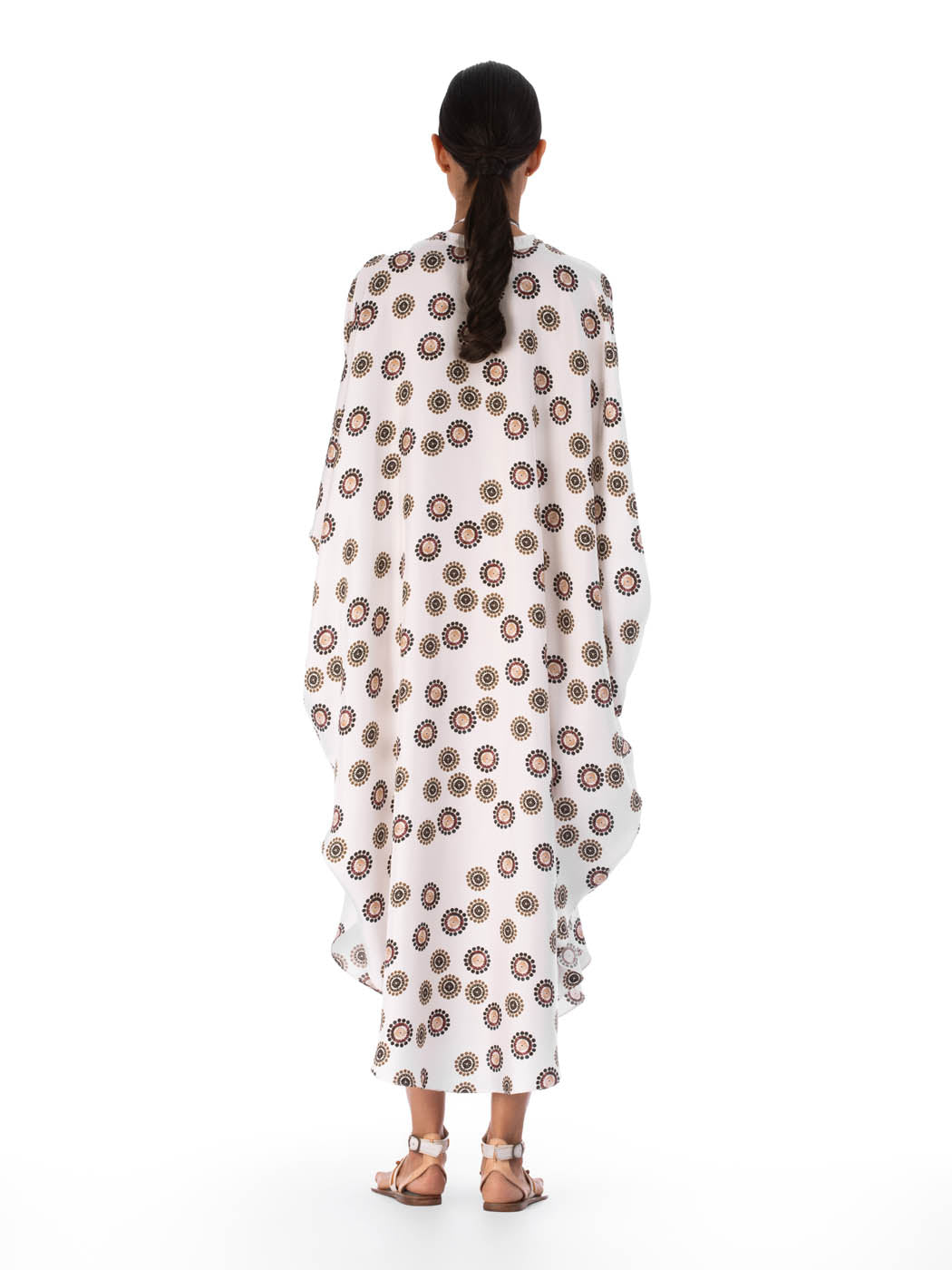 A long, white Elea Tunic Multi Sepia Floral with a mixed pattern of floral and circular designs, displayed on a transparent mannequin against a white background.