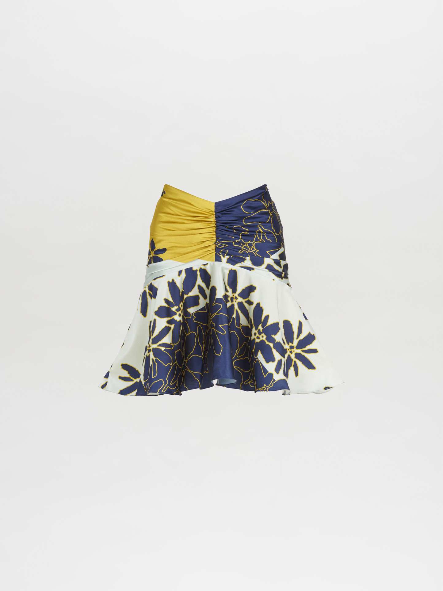 La Falda Loriana Navy Citrine presenta una tela de dos tonos con paneles amarillos y azul marino en la parte superior, una parte inferior acampanada y asimétrica estilo godet y una base blanca con estampados florales azul marino. Este diseño dinámico es parte de la colección Pre Fall 2023.