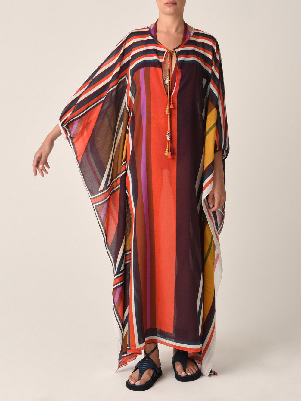The Magel Kaftan Color Block Multi from the Resort 2023 collection is a multicolored striped piece featuring a keyhole neckline and tassel tie closure. This kaftan offers a loose, flowing fit with an asymmetric hem in color block multi pattern voile, ensuring both comfort and style.