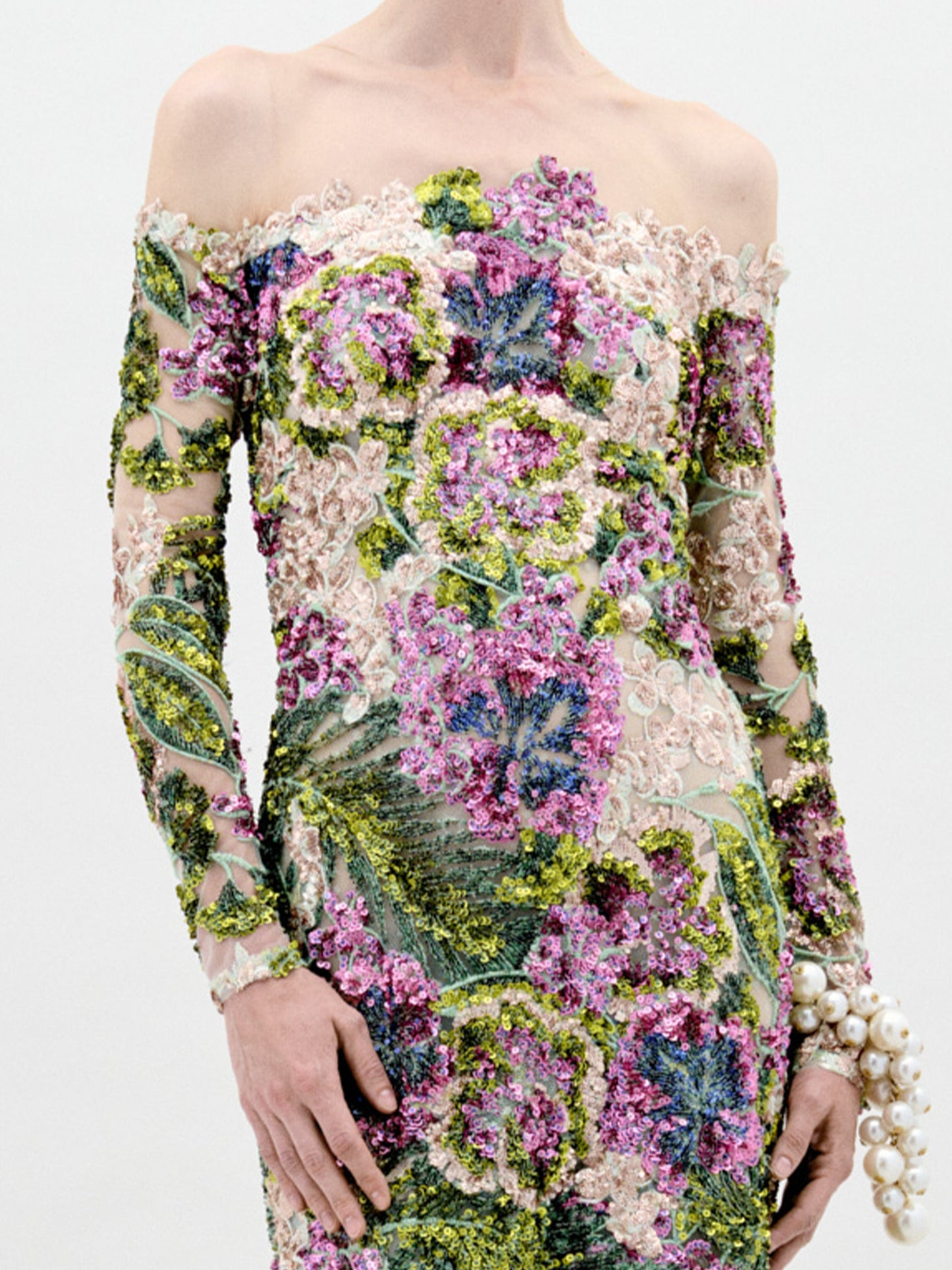 A person stands against a plain background wearing the Rafaella Dress