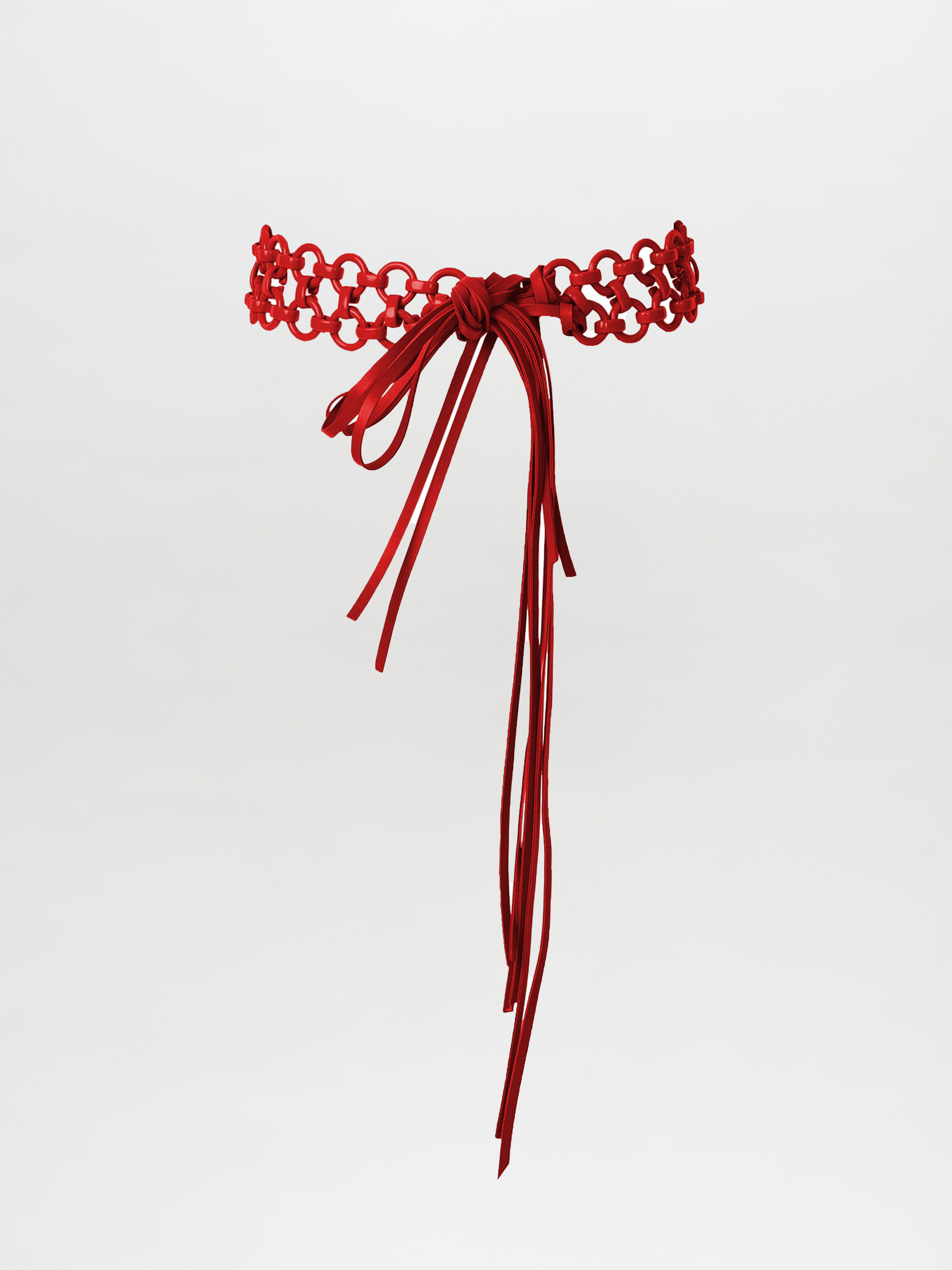 Coral and magenta Sindione belt featuring a braided design and long tassels against a white background.